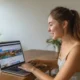 Иностранец в Бали подает онлайн-заявку на визу в Россию, на экране ноутбука форма, рядом паспорт, страховка, билеты и бронь отеля, на фоне тропический пейзаж 🌴💻
