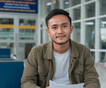 バリ島で南アフリカビザ申請書類を準備するインドネシア人旅行者。パスポート、航空券予約、宿泊証明、銀行残高証明、旅行保険をVFS予約前に揃えている様子。